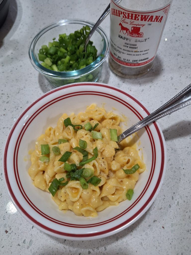 bowl of macaroni and cheese topped with green onions